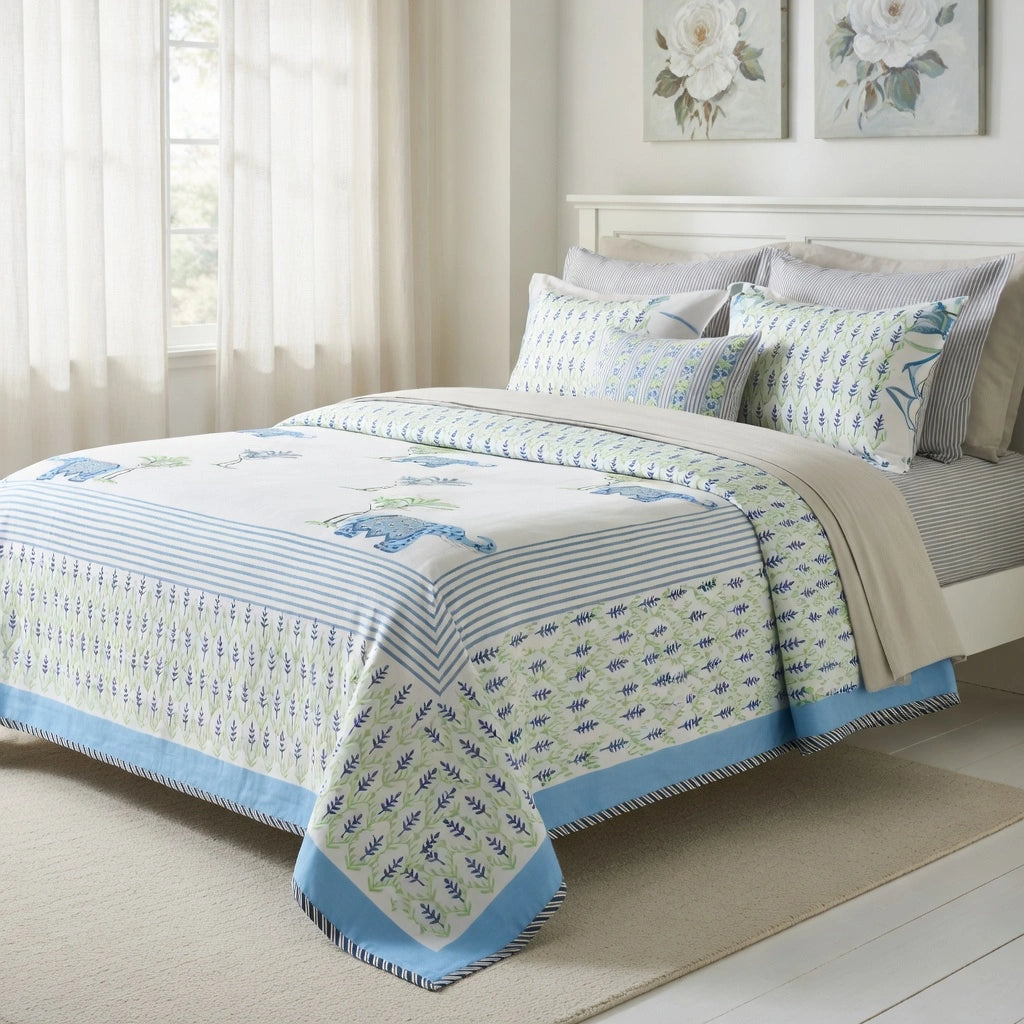 A bed dressed in a light blue and white patterned bedding set with matching pillows, styled in a bright, neutral bedroom setting.