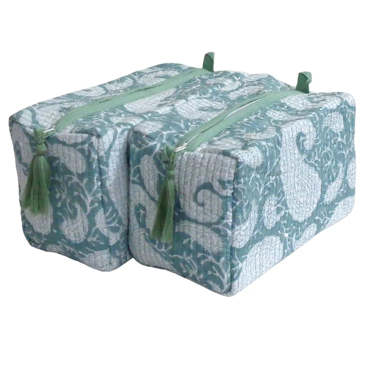 Two quilted fabric zippered storage bags with a teal and white paisley pattern and green tassels, shown on a plain white background.