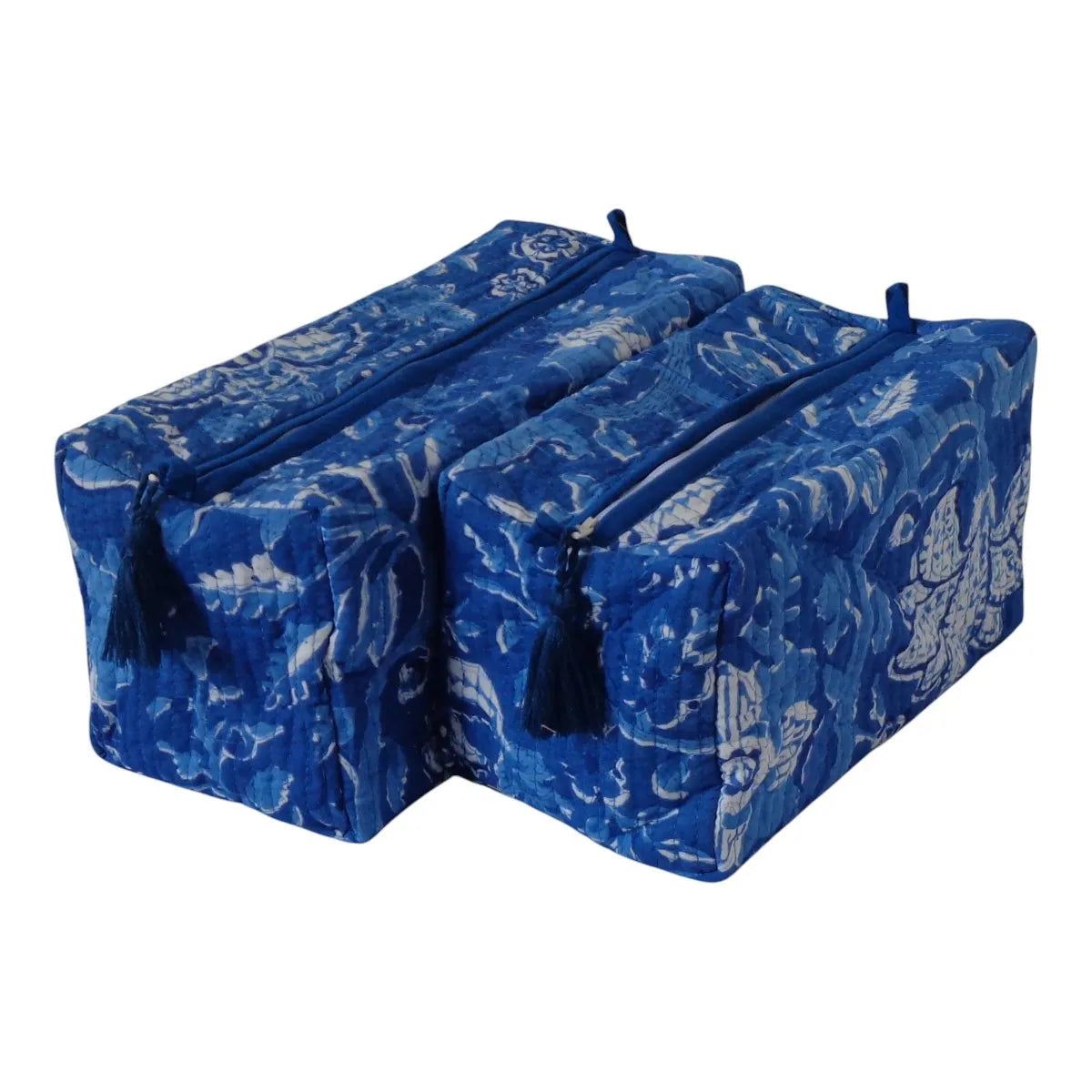 Two blue zippered storage bags with a white batik-style floral pattern and black tassels, shown on a plain white background.