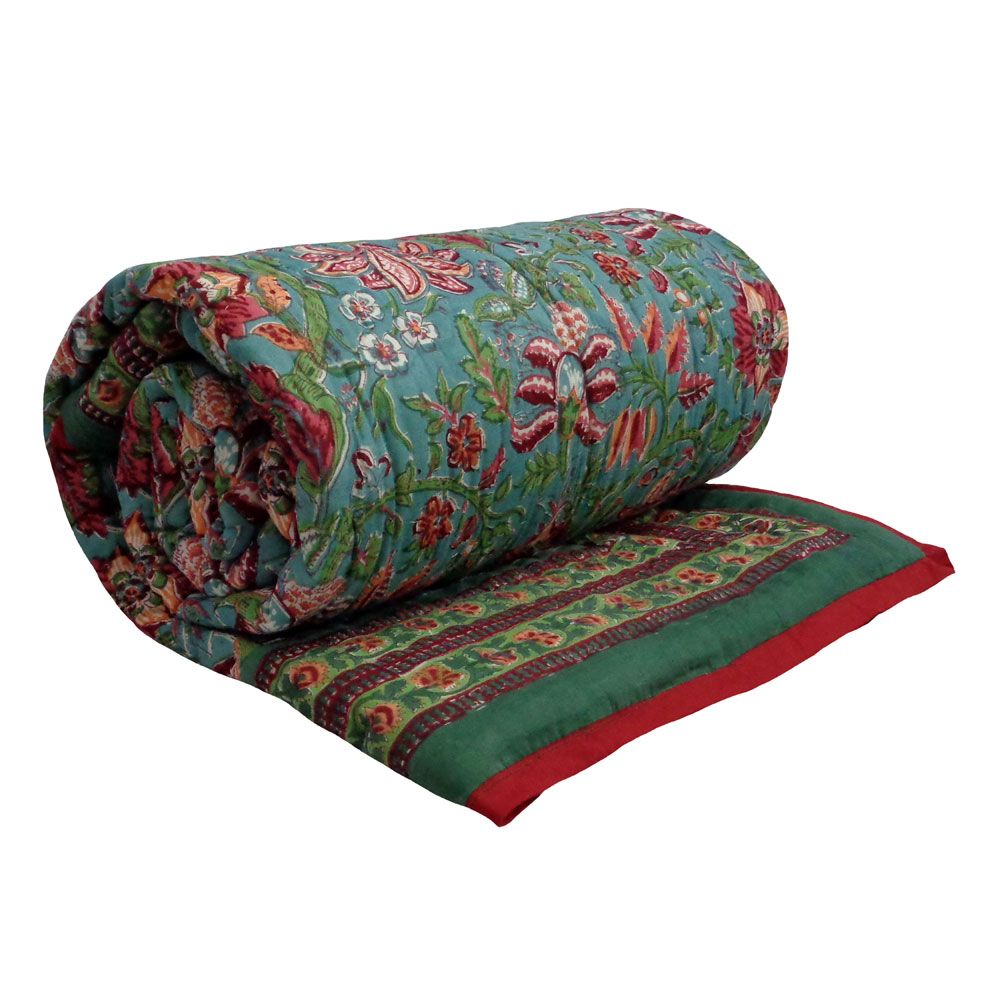 A rolled-out quilted comforter with a vibrant floral and paisley pattern on a teal background, featuring a green border with red and gold accents, set against a plain white background.