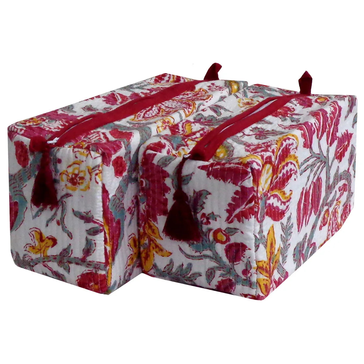A pair of yoga props, specifically rectangular bolster pads, featuring a white background with a vibrant red, yellow, and gray floral pattern, accented by dark red tassels and red zipper pulls.