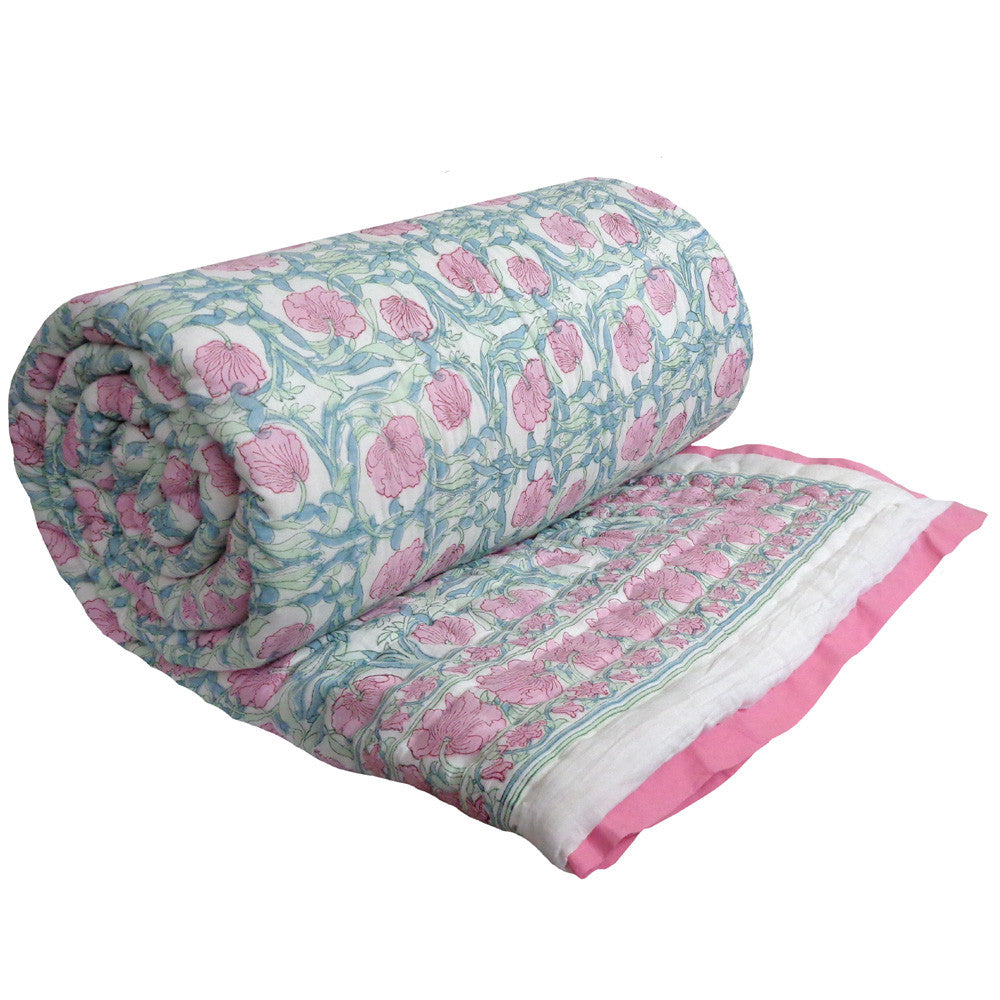Roll of floral-patterned fabric with pink and green design on a white background