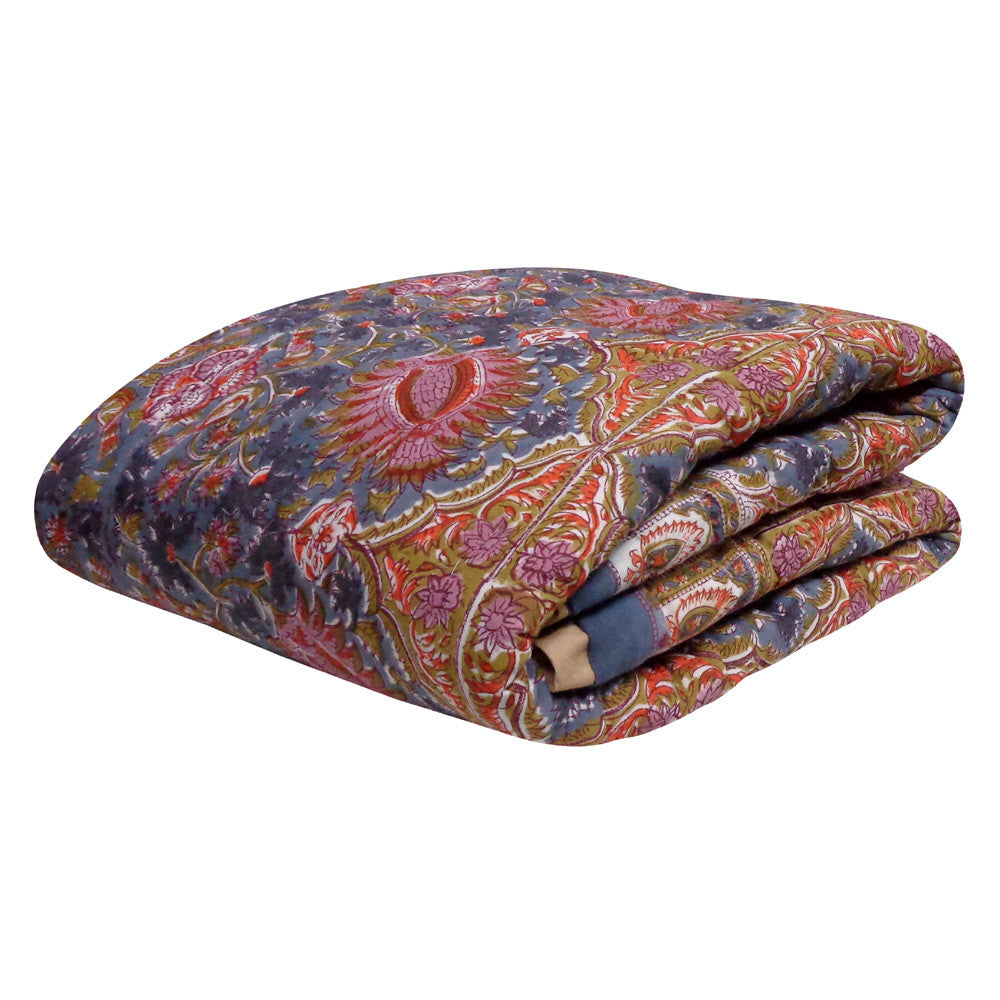 A folded patterned throw blanket with a traditional paisley design in red, pink, blue, and gold tones, shown on a plain white background.