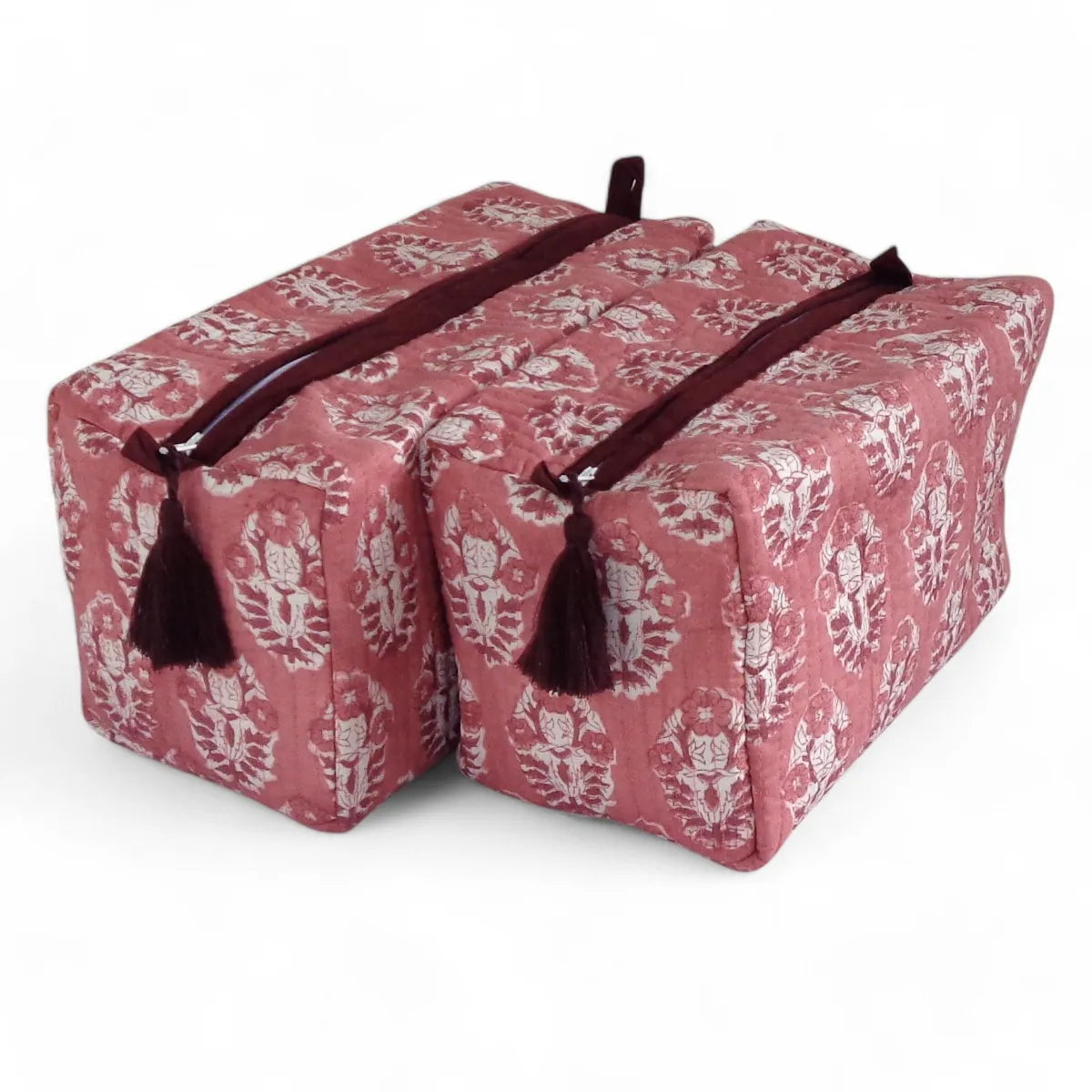 Two rectangular bath or body pillow cases with a dusty rose and white damask pattern, featuring dark burgundy tassels and zipper pulls, set against a plain white background.