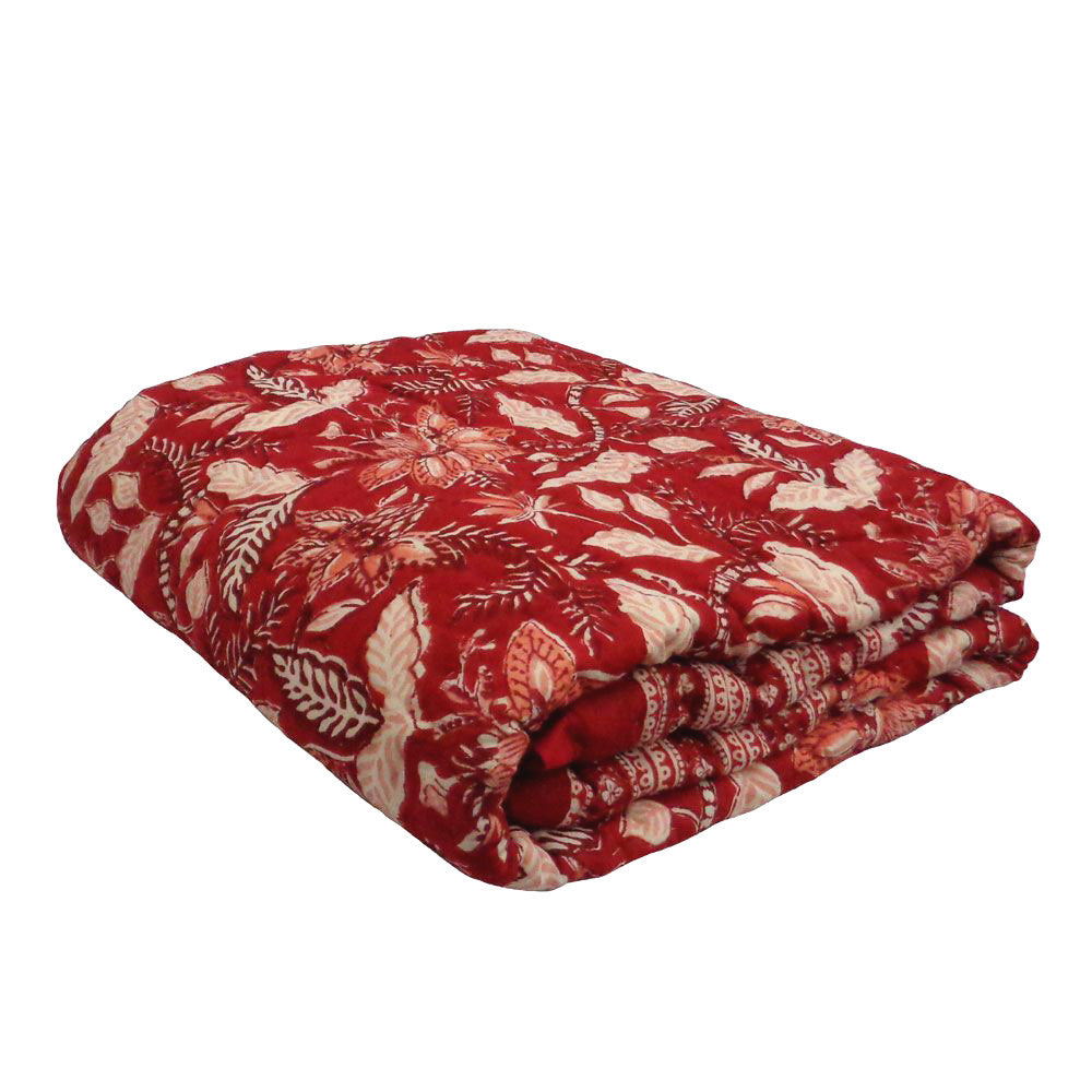 A folded red blanket or throw featuring a cream-colored floral and botanical block print pattern, shown against a plain white background.