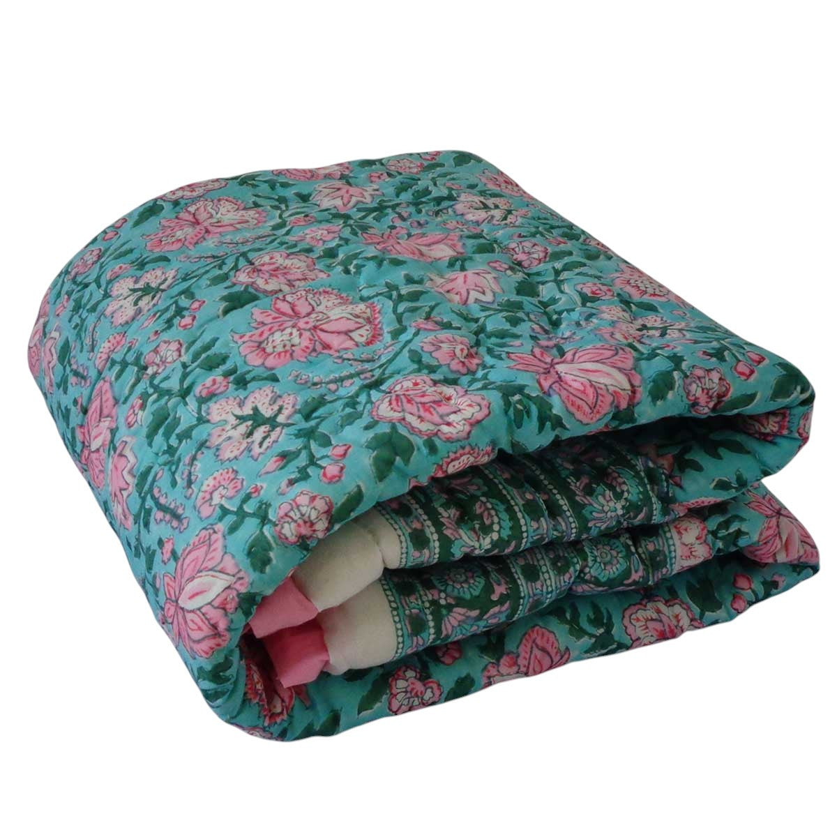 A folded quilted blanket featuring a teal green floral pattern with pink roses and green leaves, showing a soft pink fleece lining.
