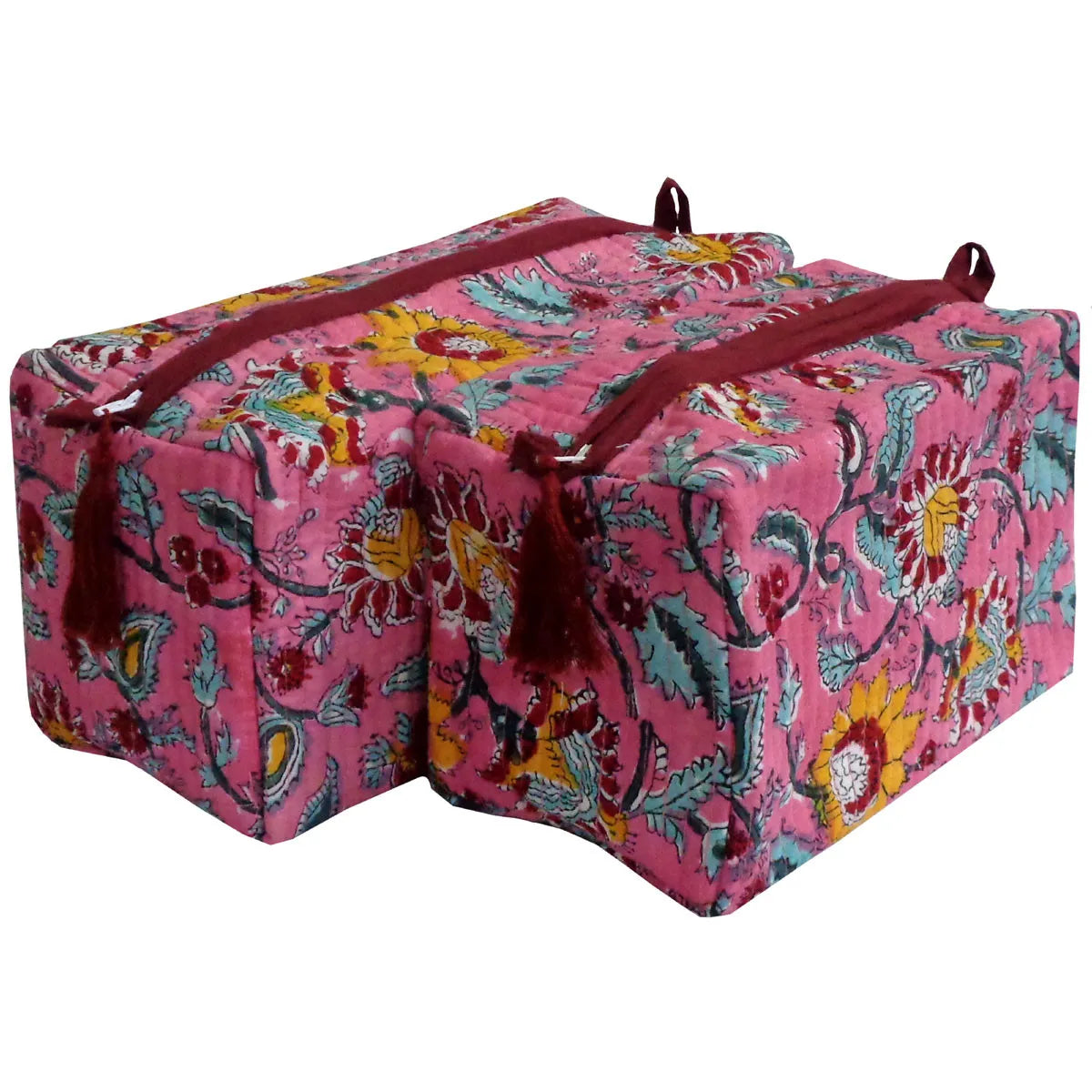 Two rectangular storage boxes with a vibrant pink floral and paisley pattern, featuring dark red handles and tassels, set against a plain white background.