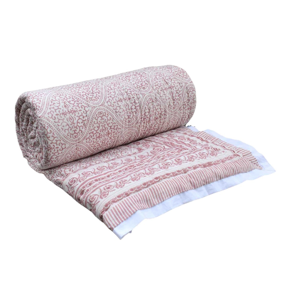 A rolled-out cotton blanket with a dusty pink and white paisley block print pattern, displayed on a clean white background.