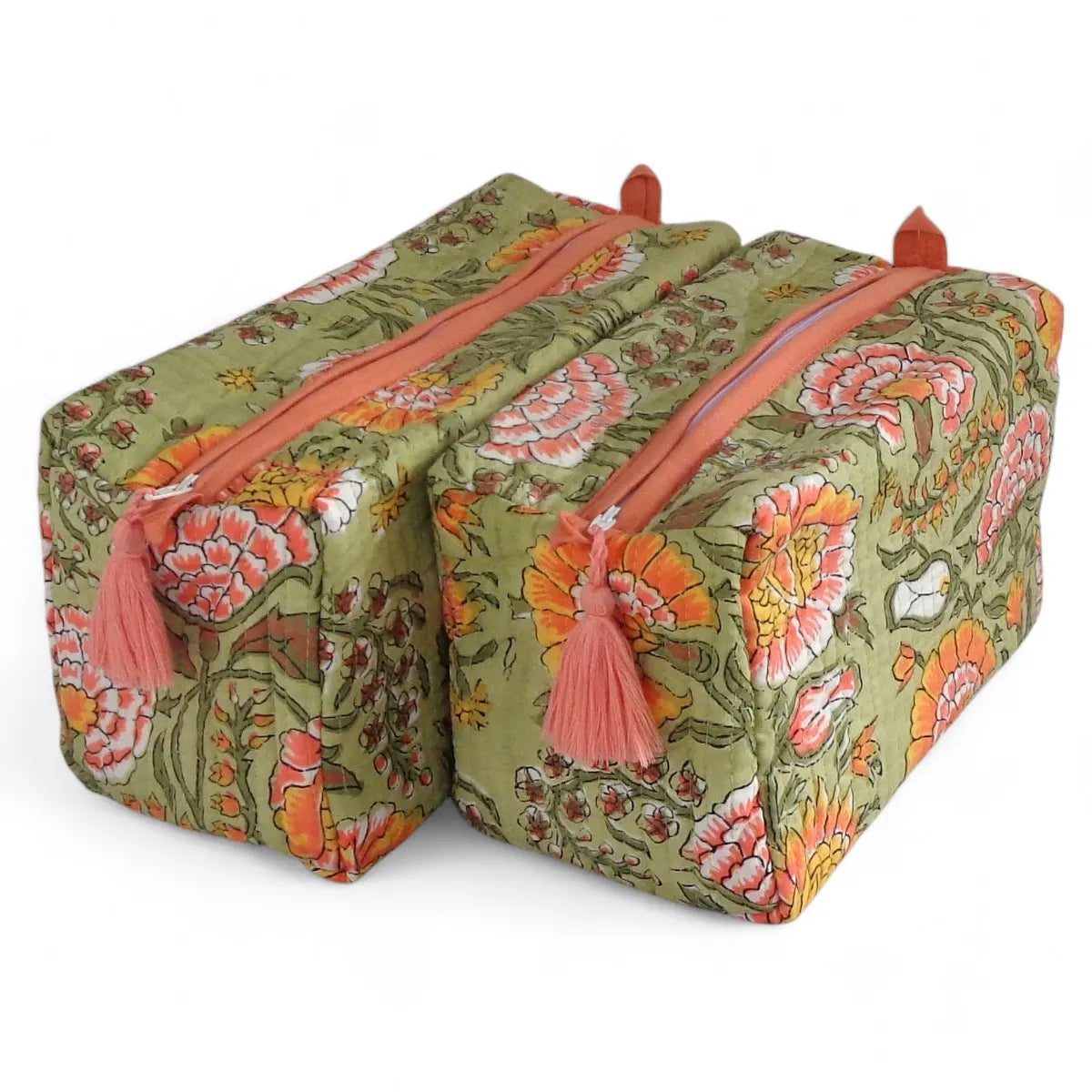 Two rectangular zippered cosmetic bags with a vintage floral print in olive green, orange, pink, and white, featuring coral pink tassels on the zippers, set against a plain white background.
