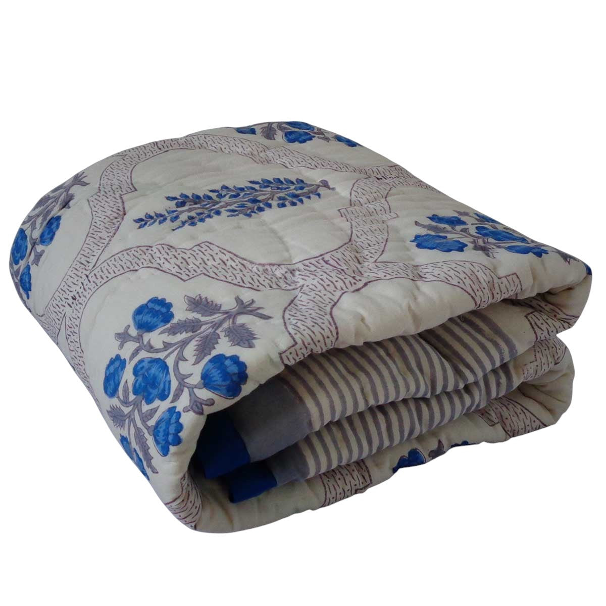 A folded quilted comforter with a cream background, blue floral motifs, and brown vine patterns, shown against a plain white background.