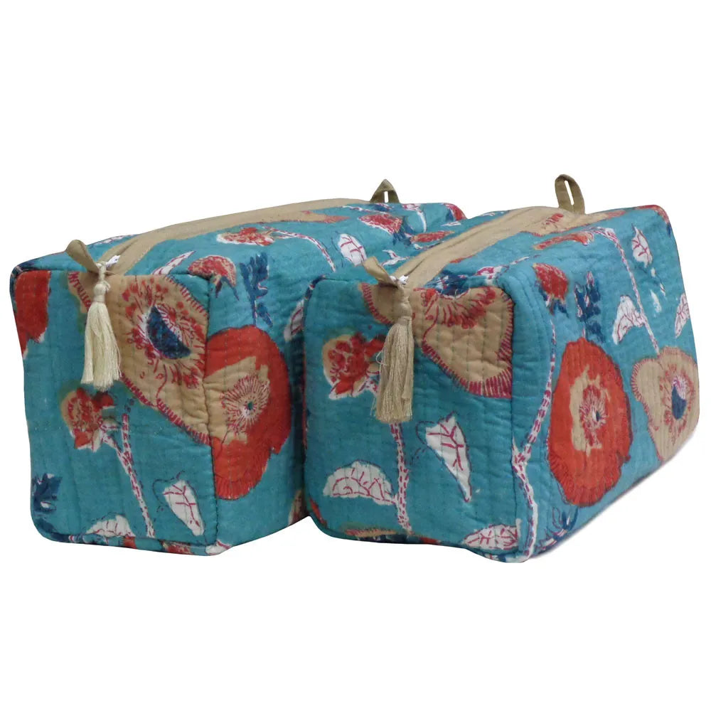 Two quilted travel or storage bags with a vibrant floral print in turquoise, red, beige, and blue, featuring cream tassels and gold-tone zipper pulls, set against a plain white background.