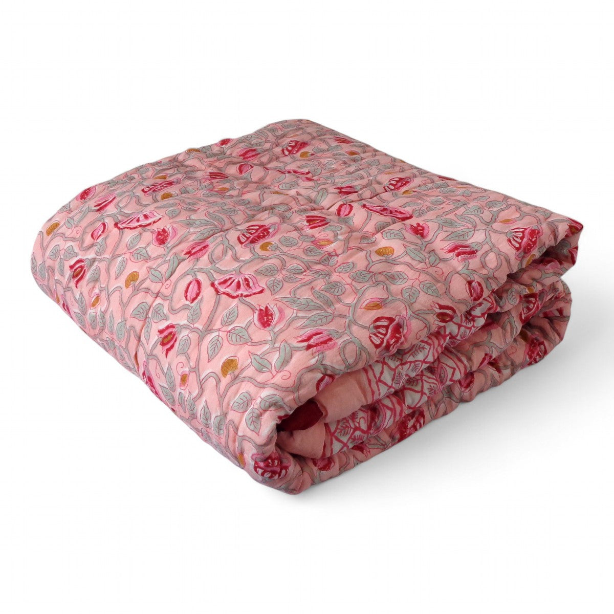 A folded quilted blanket with a pink and red floral pattern, displayed on a clean white background.