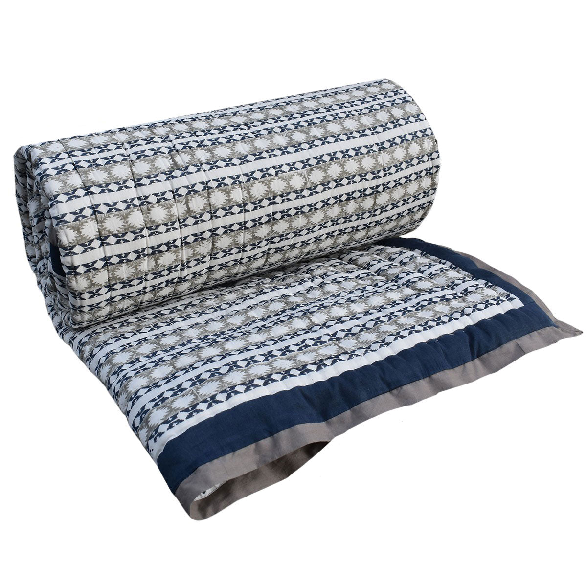 A rolled-out quilt with a geometric pattern in navy blue, beige, and white, shown against a plain white background.